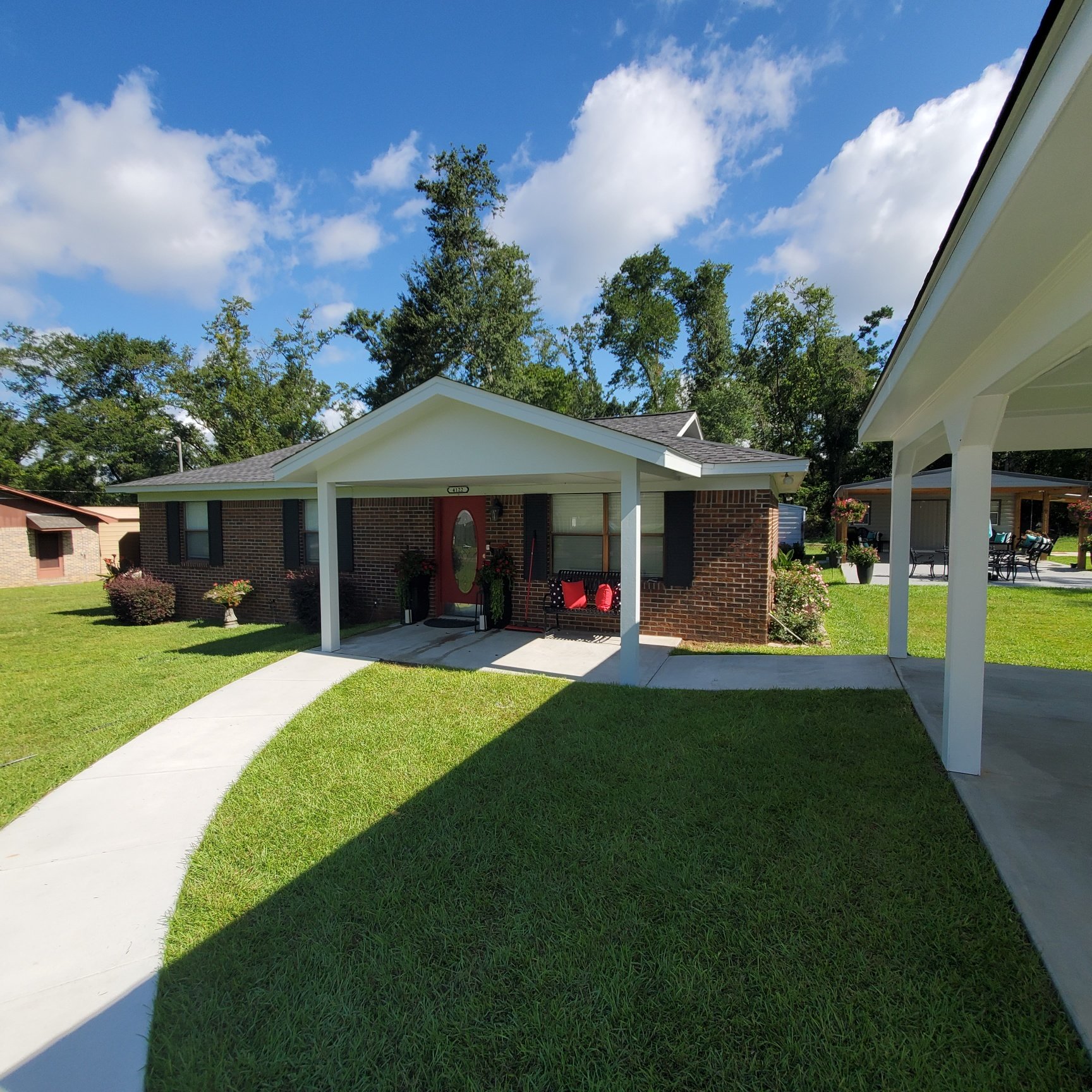 Residential brick home with covered porch and custom walkway completed by Tindall Construction.