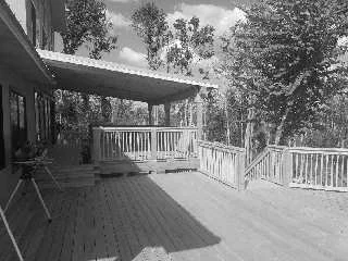 Residential wooden deck with railing attached to a private home, constructed by Tindall Construction.
