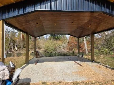 Custom carport construction featuring wood ceiling and brick columns built by Tindall Construction.