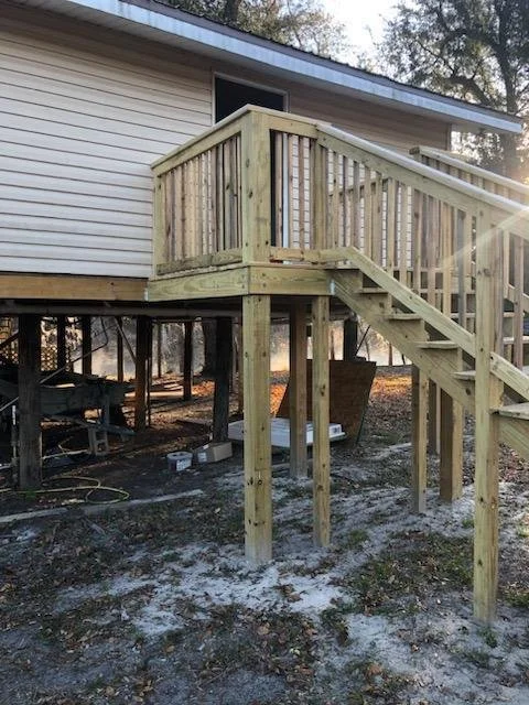 Custom wooden staircase and railing constructed by Tindall Construction for an elevated residential home.