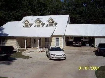 Completed residential home featuring a white metal roof and covered parking constructed by Tindall Construction.