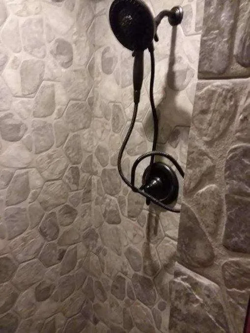 Custom shower fixture installation with wall-mounted and handheld shower system by Tindall Construction.
