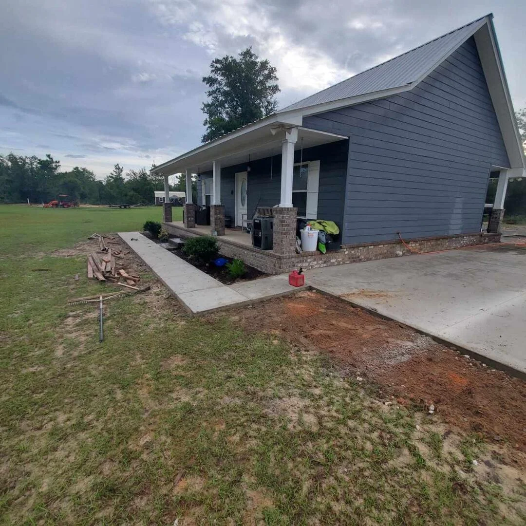 Residential exterior renovation with new concrete walkway and driveway work completed by Tindall Construction.