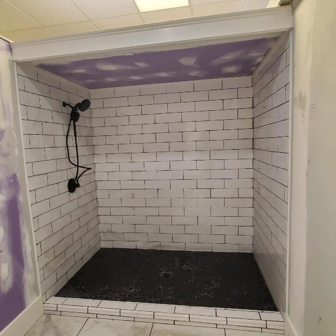 Custom tiled shower installation with subway tile walls and modern fixtures completed by Tindall Construction.