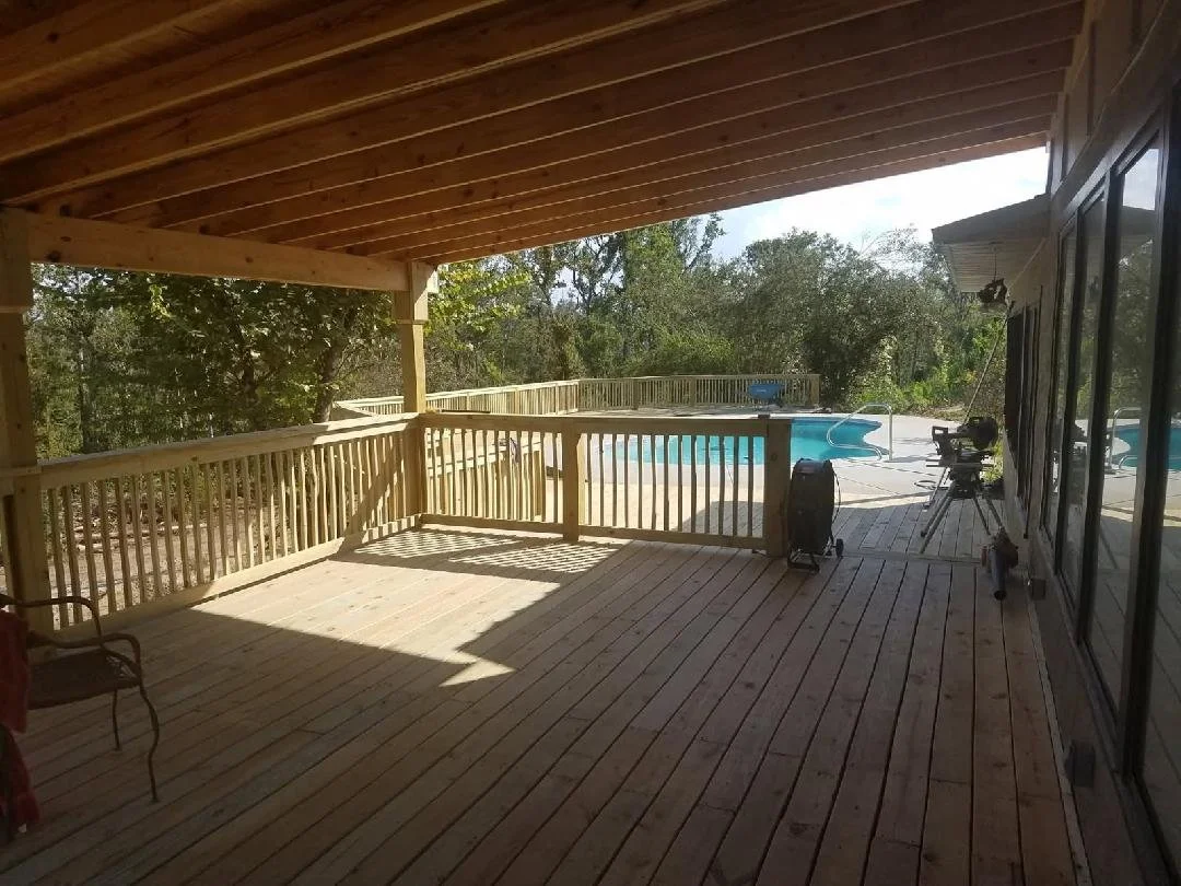 Covered wooden deck overlooking a backyard swimming pool, built by Tindall Construction.