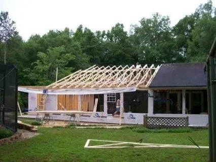 Custom home under construction with roof framing in progress by Tindall Construction.