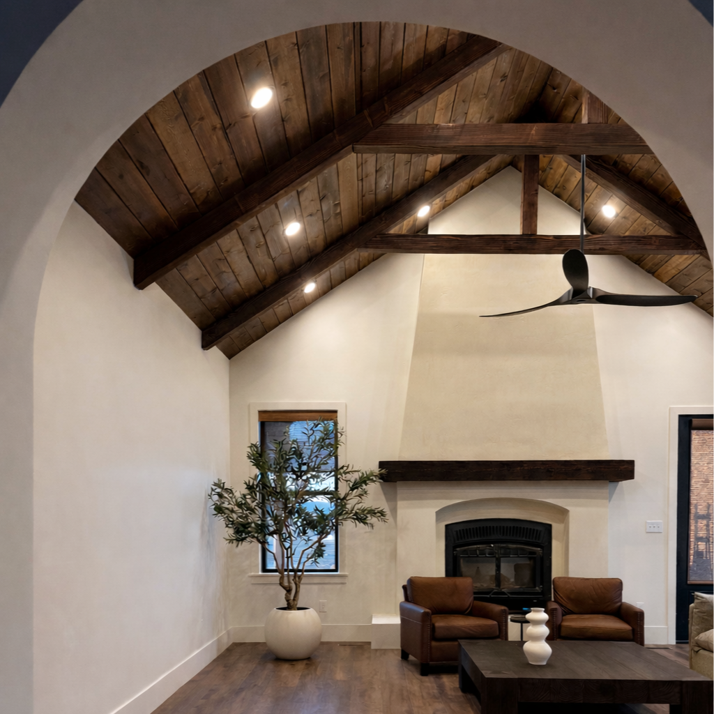 Modern white kitchen with an island, black barstools, and pendant lights.