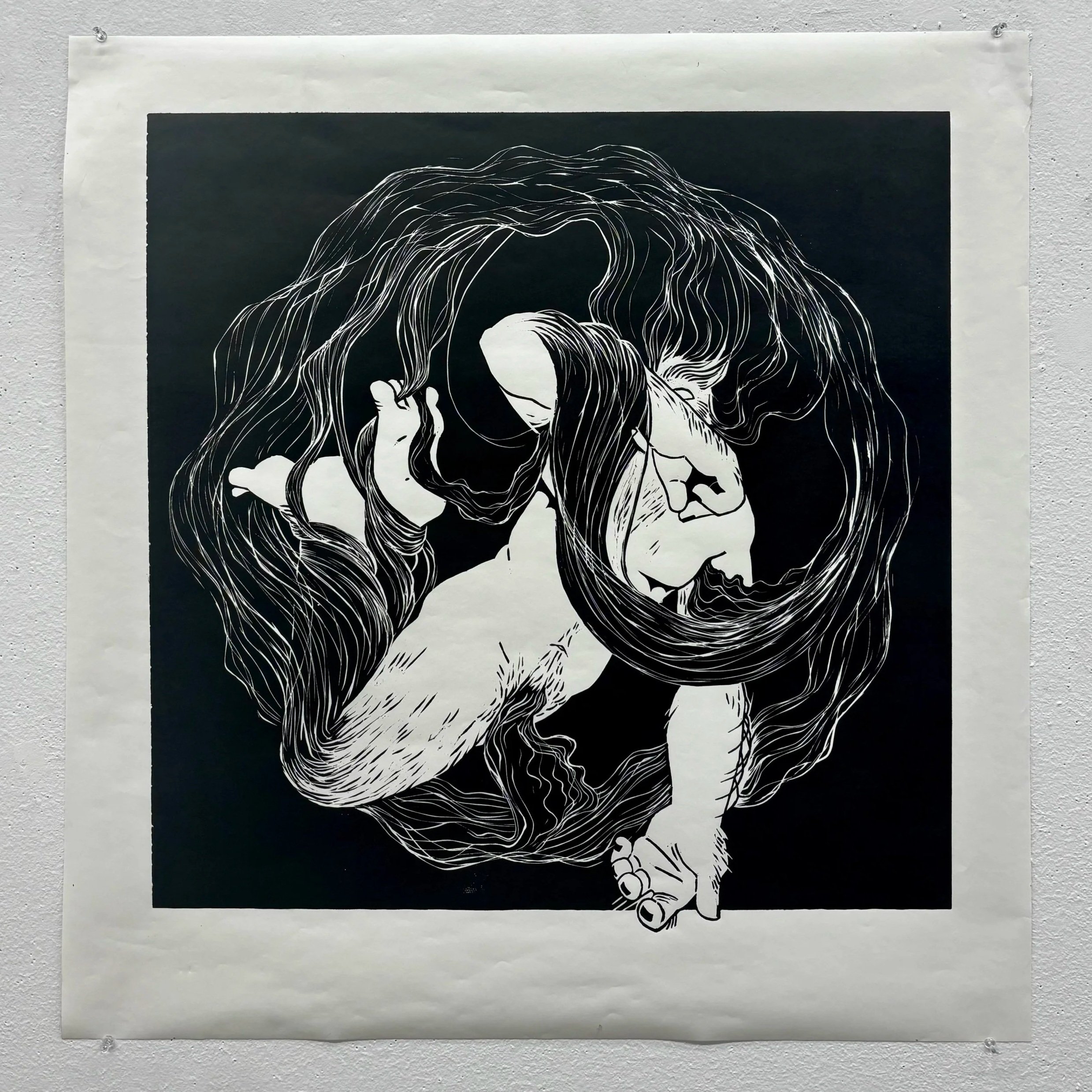 Black and white illustration of a transgender man with long flowing body hair swirling around him, floating with one hand on the ground and the other near his face.