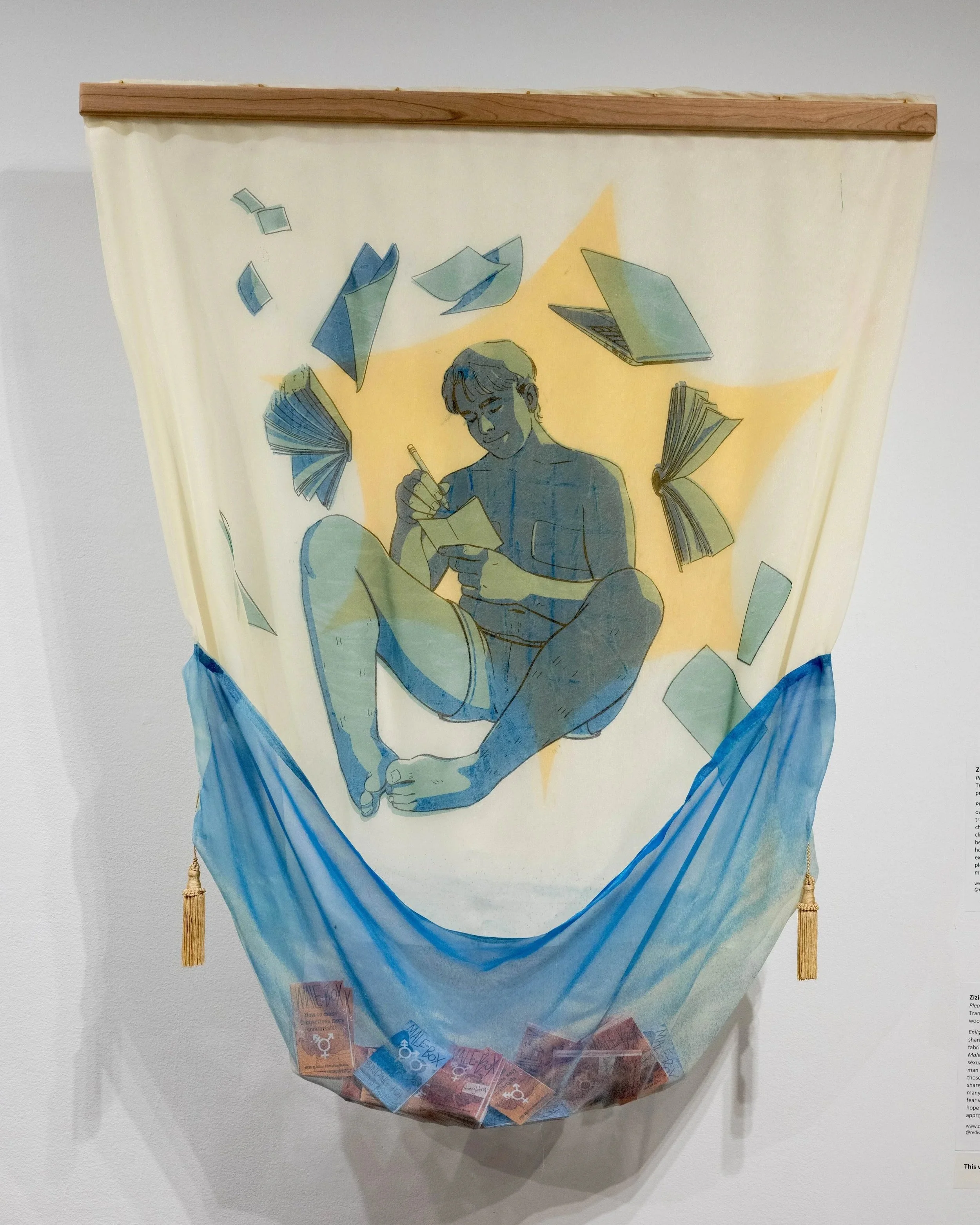 Screenprinted artwork depicting a transgender person sitting with crossed legs, writing in a notebook while surrounded by floating books and papers, with a pocket underneath holding zines, and a wooden rod at the top holding it up.