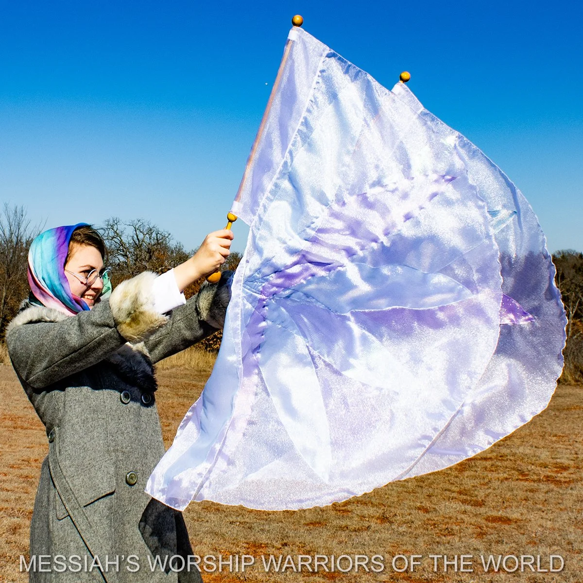 Spin-Tube worship flags in motion with the image of a lily on them to represent how God provides for the lilies of the field in the same way He does for us.