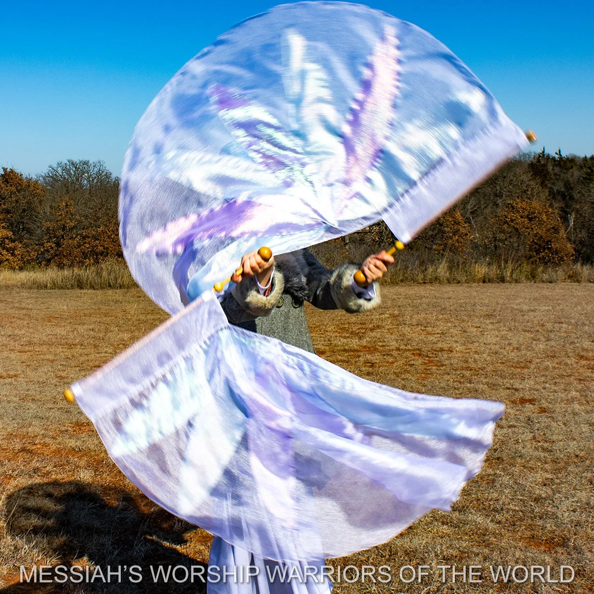 Spin-Tube worship flags in motion with the image of a lily on them to represent how God provides for the lilies of the field in the same way He does for us.