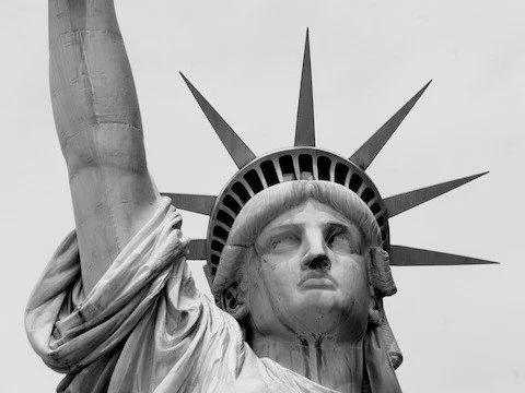 Close-up of the Statue of Liberty's face and crown in black and white.