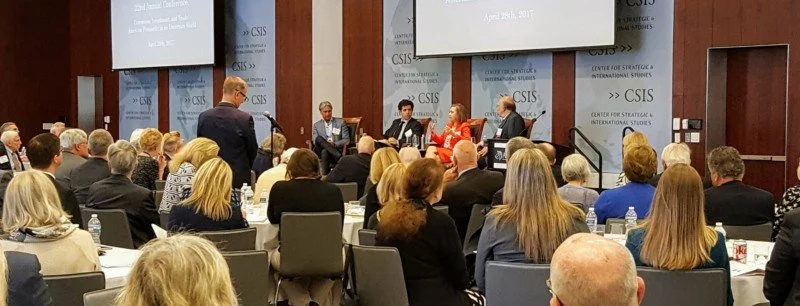 Panel discussion at a conference with multiple speakers seated at a table in front of an audience, held at the Center for Strategic & International Studies.