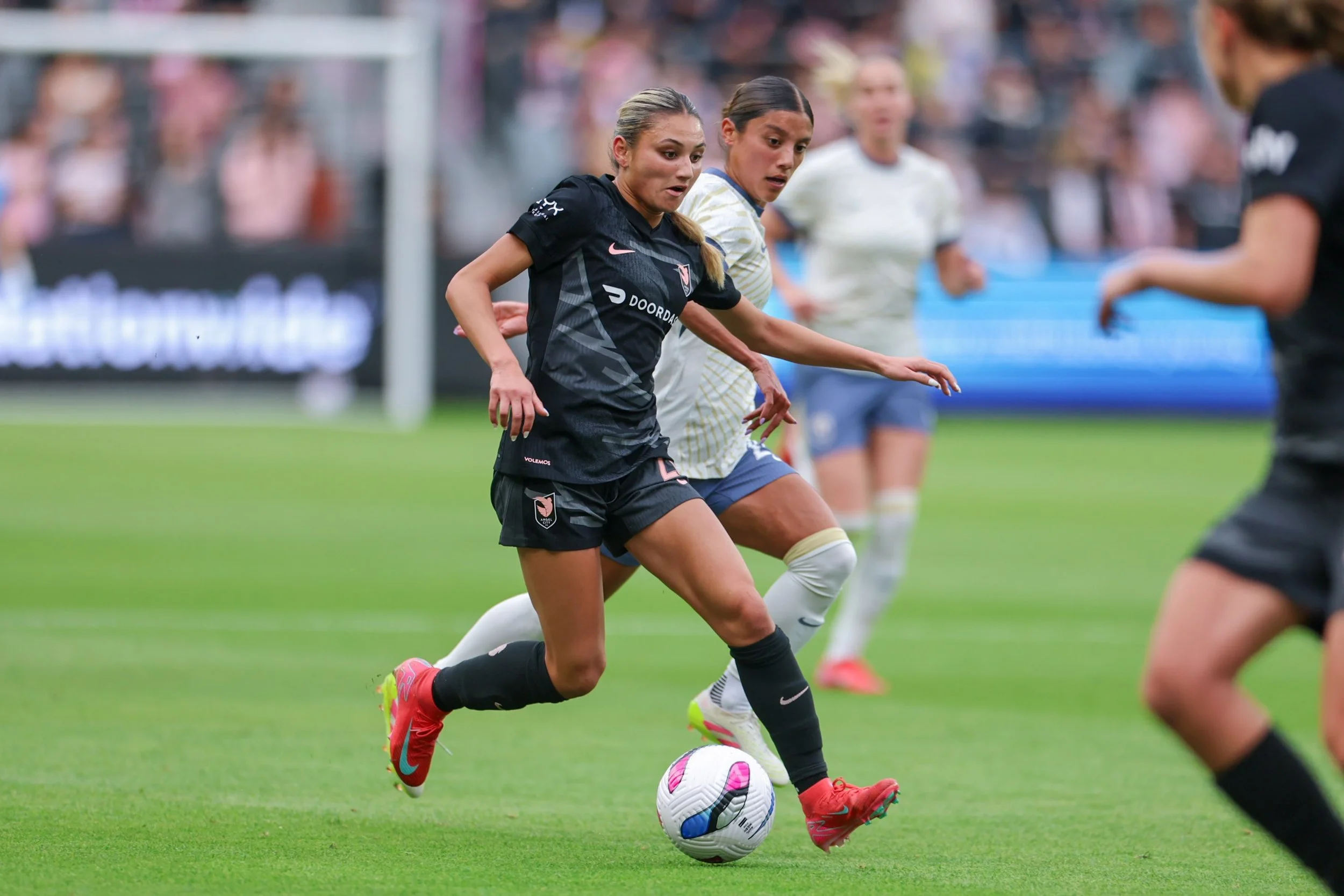 Gisele Thompson beating a defender while playing for ACFC