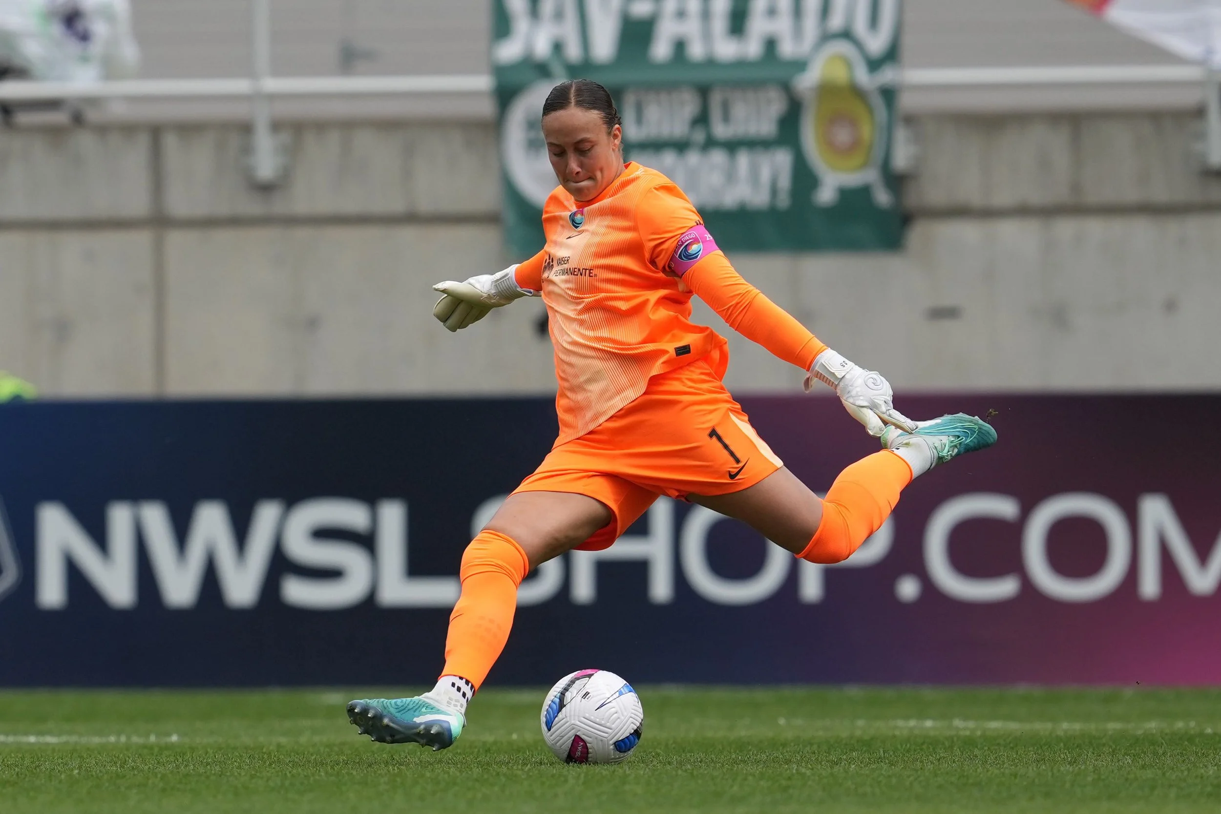 Goalkeeper Kailen Sheridan wears all orange as she kicks the ball for San Diego Wave FC