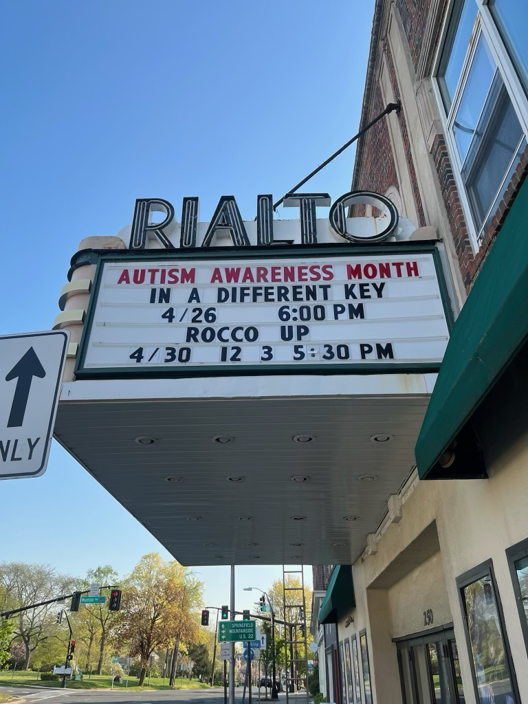 The Rialto movie theater marquee displaying information about Autism Awareness Month events on April 26 and April 30.