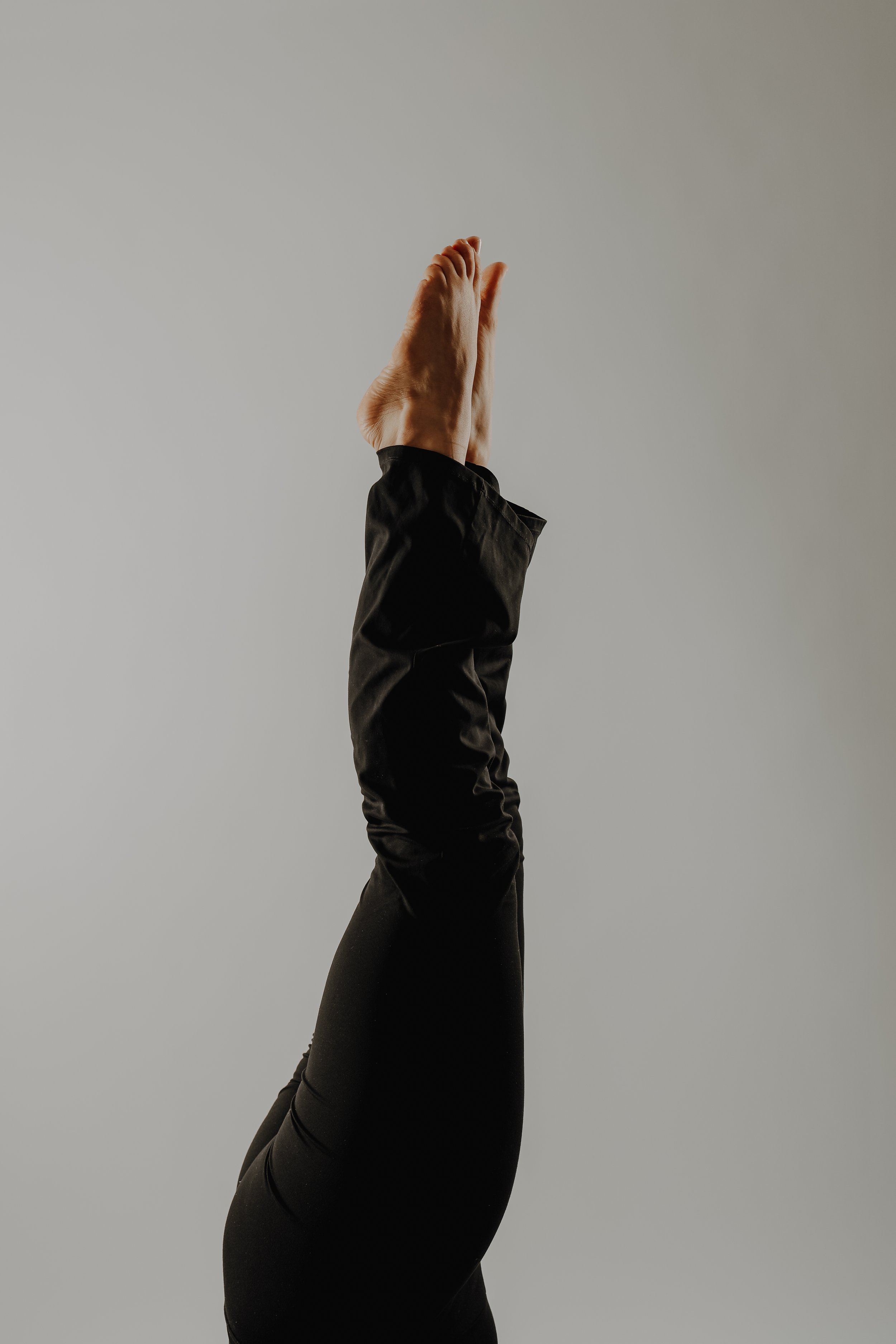 Nahaufnahme einer ausgestreckten Hand in Yoga- oder Meditationspose vor hellem Hintergrund.