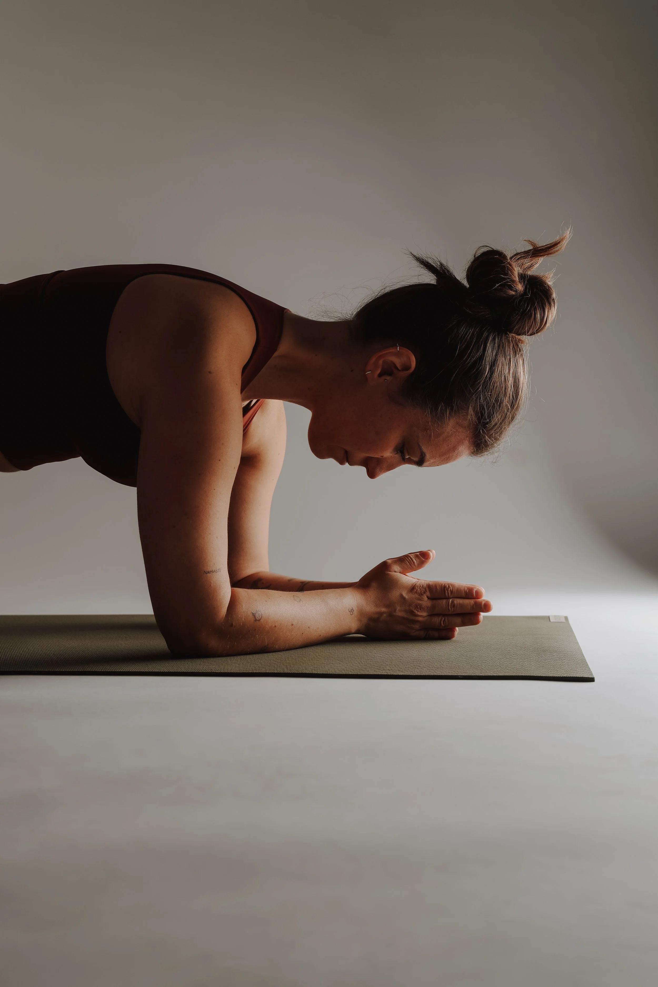 Skelletierte Frau macht Yoga auf einer Matte in einer hellen, minimalistischen Umgebung.