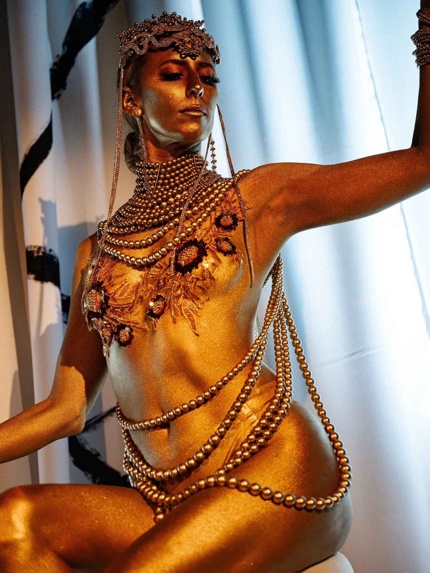 Gold, glamour, and mythic allure. 

A Medusa Crown-inspired living statue takes center stage&mdash;crowned in gold and framed by a glittering contortion duo&mdash;for an unforgettable Versace-mansion&ndash;themed evening. Elevated, sculptural, elegan