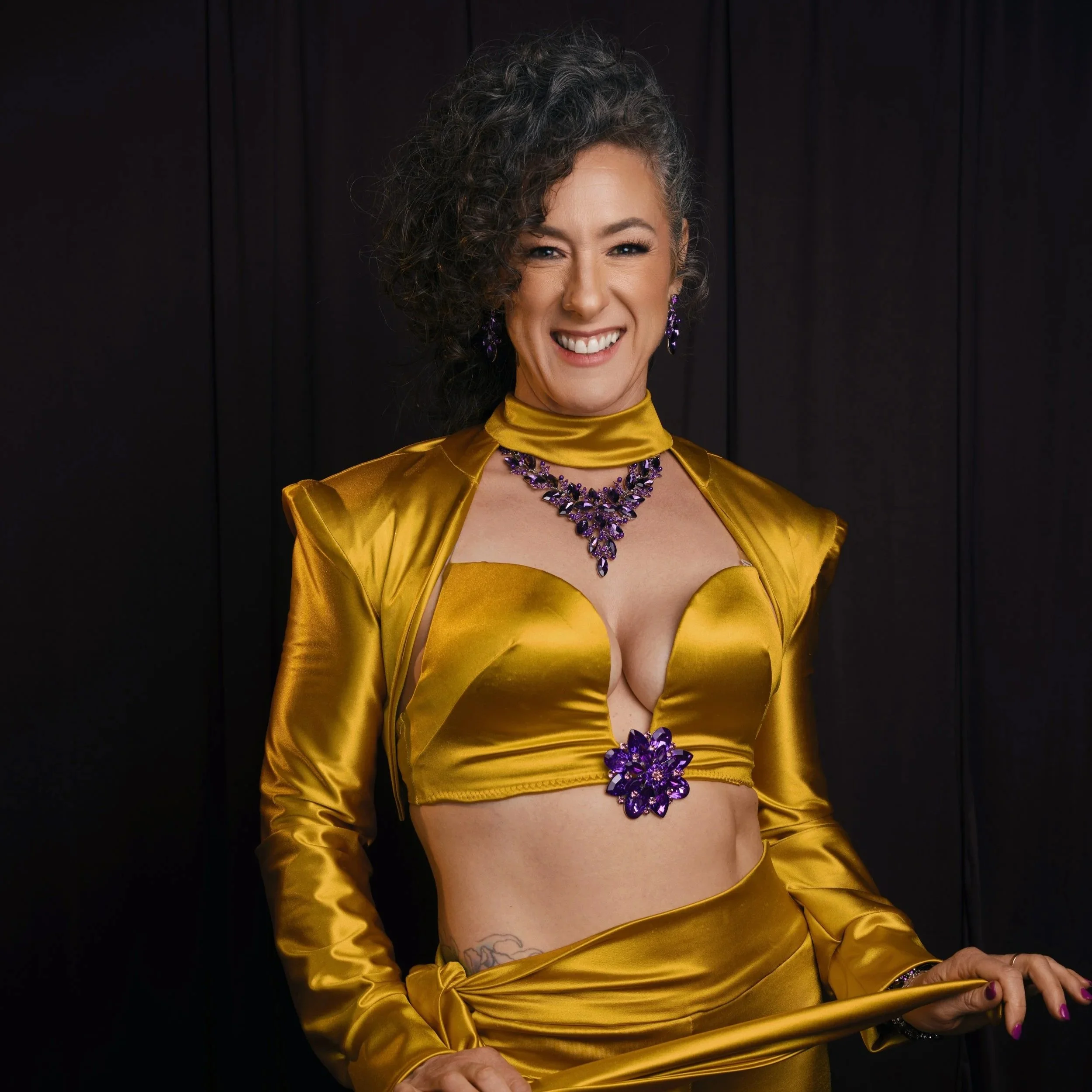 Gwynne Flanagn in yellow satin dress with purple rhinestone accents