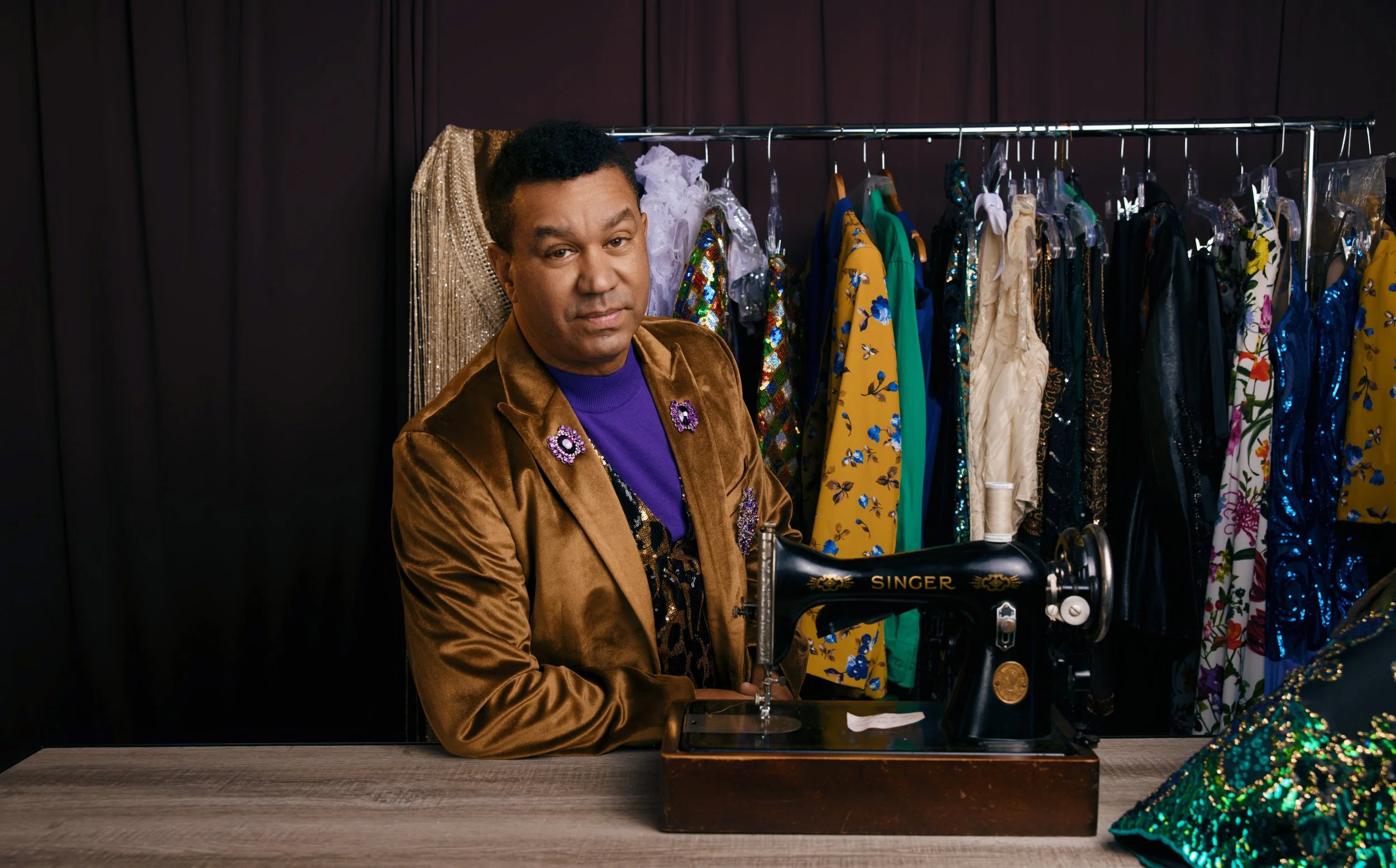 William Linares in velvet brown suit, purple shirt.