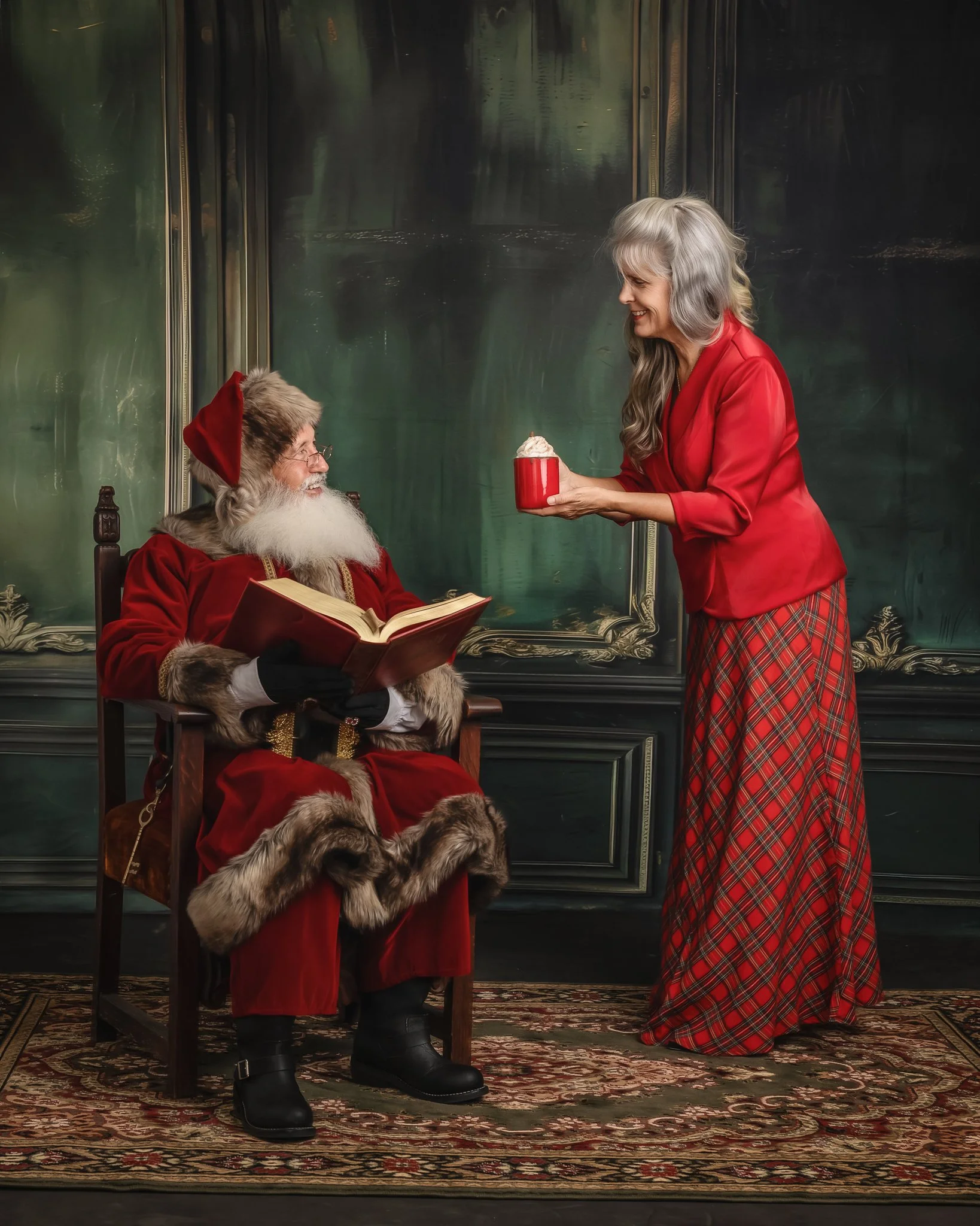 An elderly woman is offering a cup of whipped cream to a man dressed as Santa Claus, who is sitting in a chair and holding a book. They are in a cozy room with dark green walls and a rug on the floor.