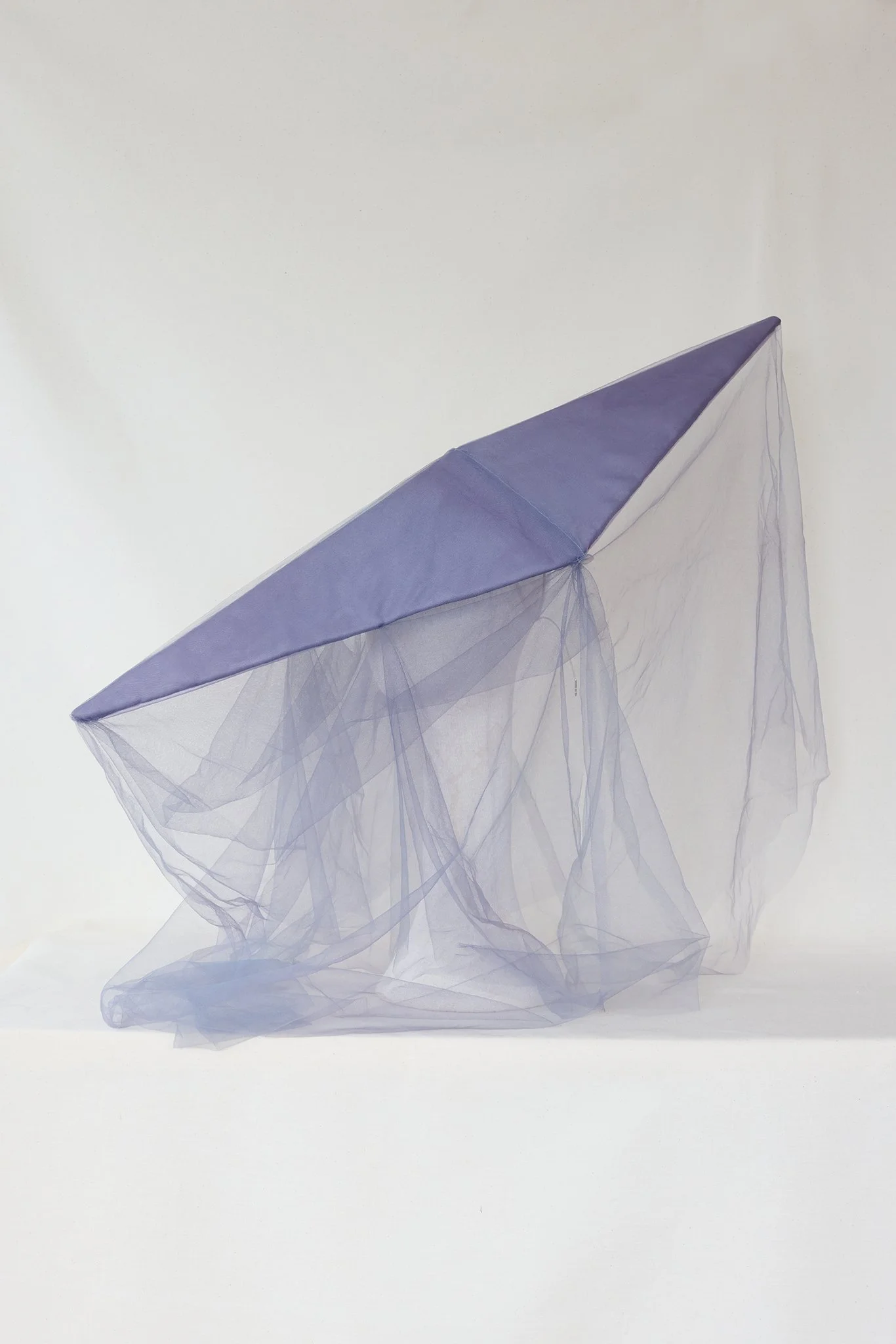 A pastel purple umbrella with transparent fabric drapes underneath on a white background.
