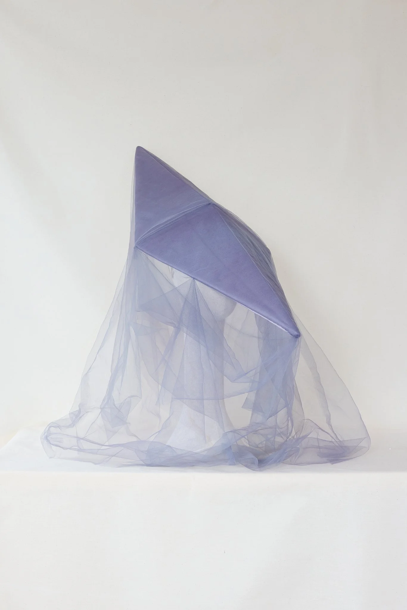 A purple translucent umbrella with sheer purple fabric draped over it, placed against a white background.