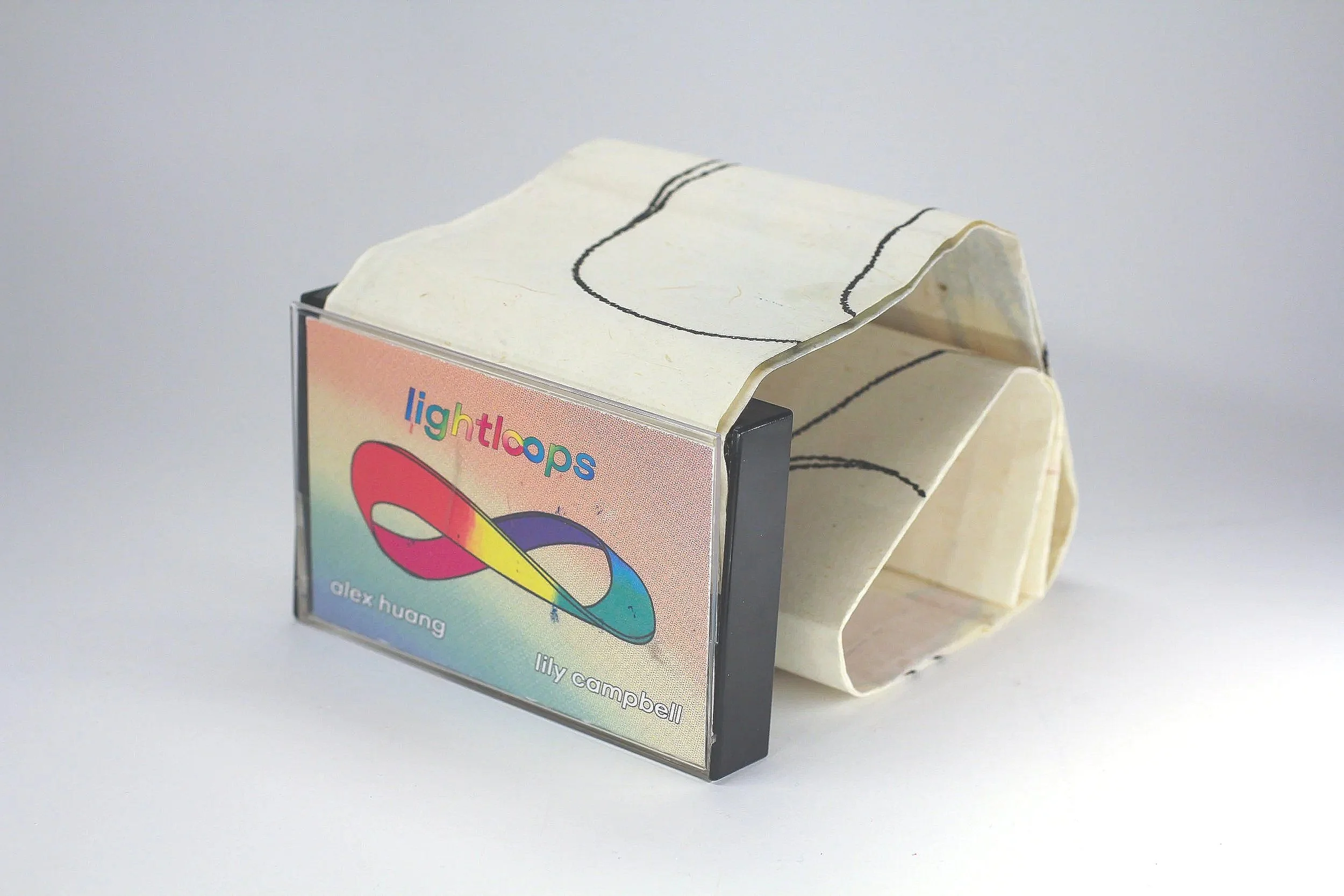 Light Loops by Alex Huang and Lily Campbell - 

Detail view of package with unfurled outer sleeve and removed mobius strip exterior