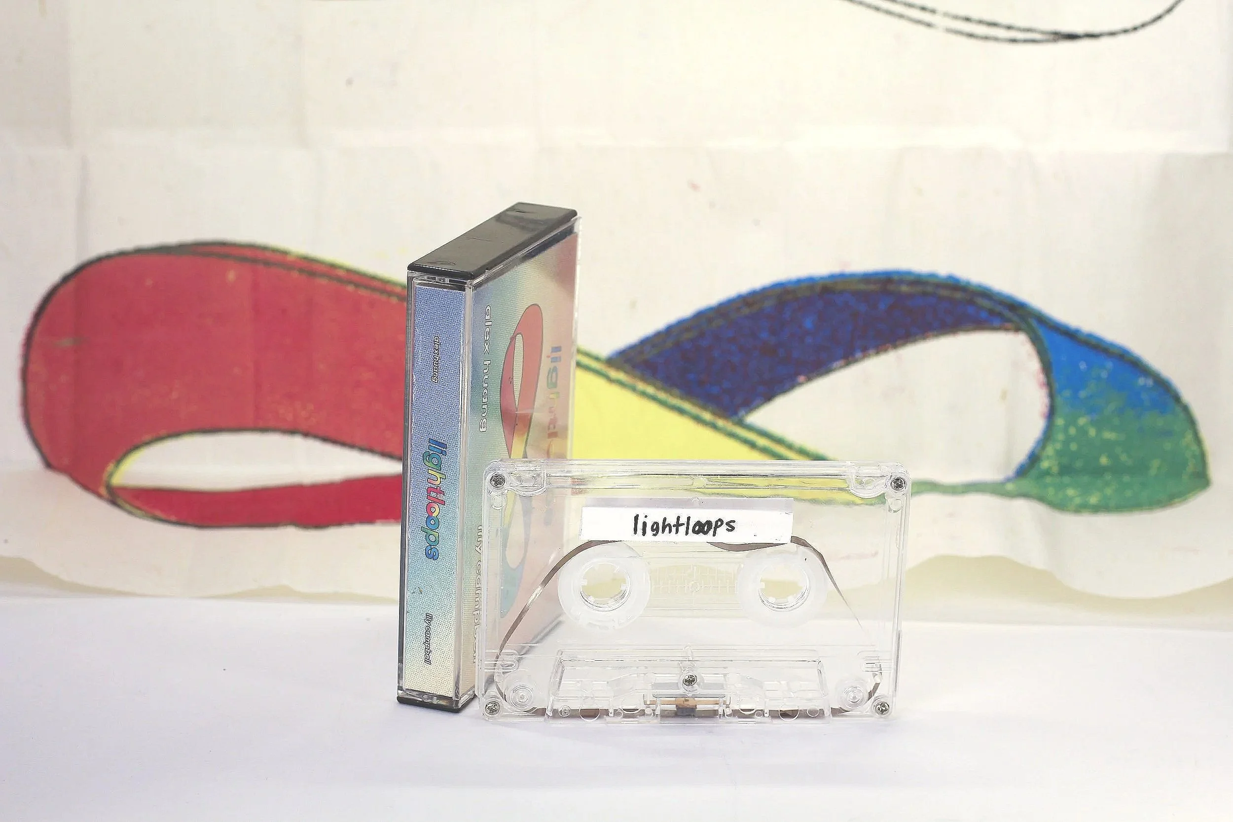 Light Loops by Alex Huang and Lily Campbell - 

Detail view of full package with cassette tape loop and removed and unfolded mobius strip exterior