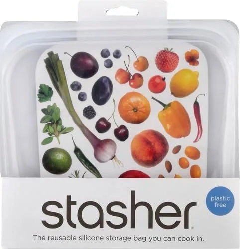 A clear plastic storage bag with a label reading "stasher" and an illustration of various fruits and vegetables, including a lemon, red pepper, strawberries, cherries, blueberries, blackberries, onion, chili pepper, and others.