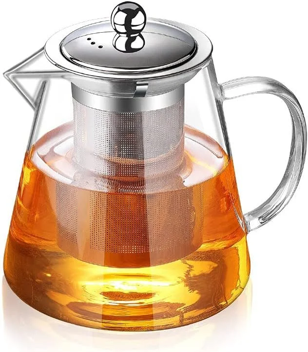 Glass coffee pot filled with hot tea and a metal infuser inside.