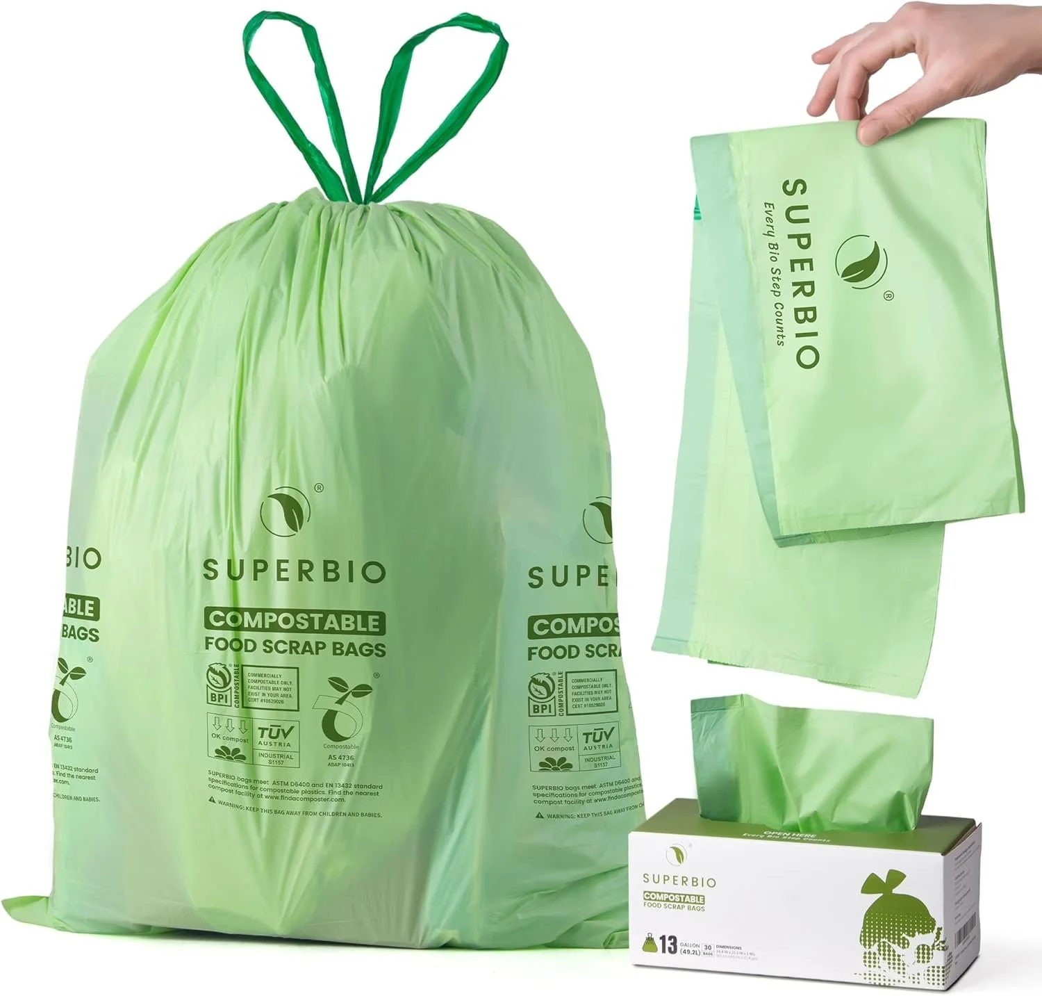 Green compostable food scrap bags from Superior Bio, with a large bag, a box of tissues, and a hand holding a smaller bag against a white background.