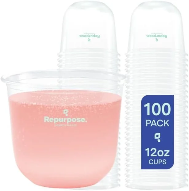Pack of 100 disposable cups, with some filled with pink liquid, stacked behind the cups.