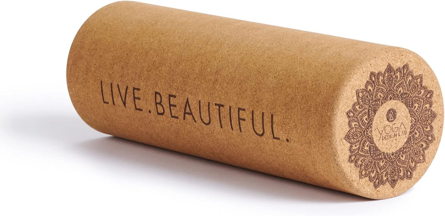 A brown yoga mat with the words "LIVE. BEAUTIFUL." printed on it and a decorative circular logo that reads "YOGA DESIGN LAB."