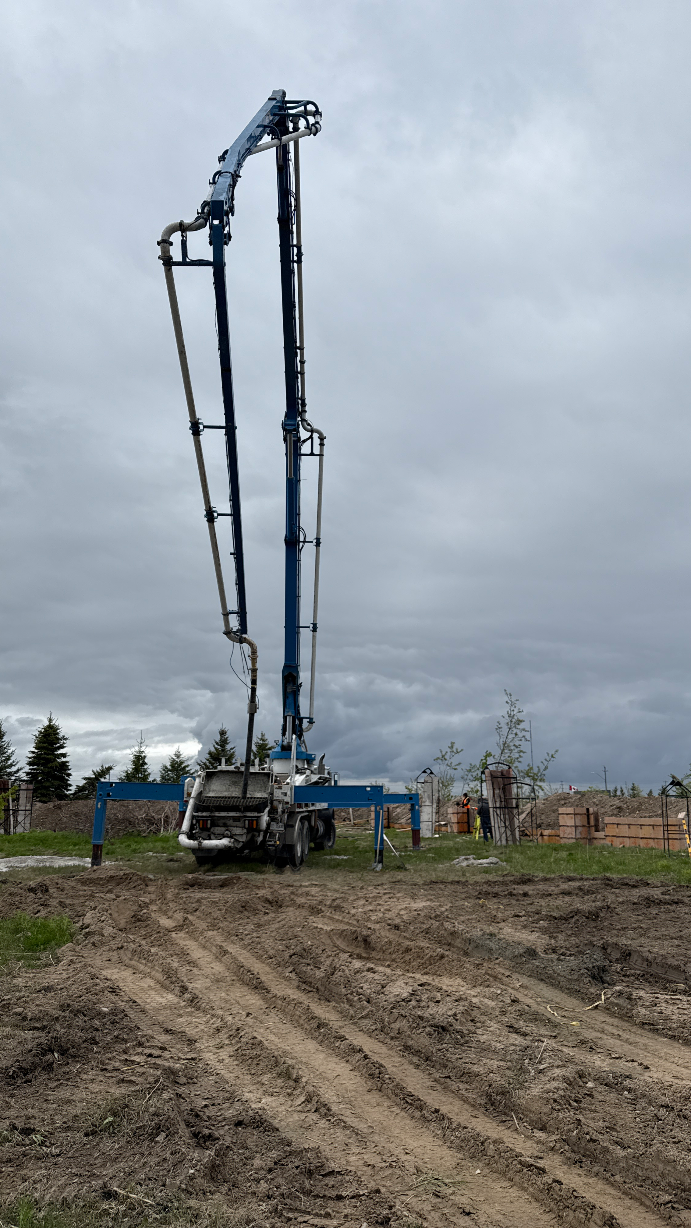 A concrete pump truck on site pouring concrete foundation. 