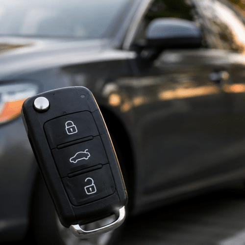person pressing a button on a car key fob with no response