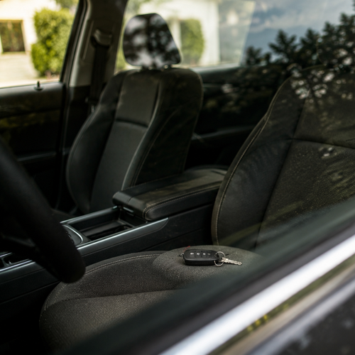 person locking keys in car looking frustrated through window