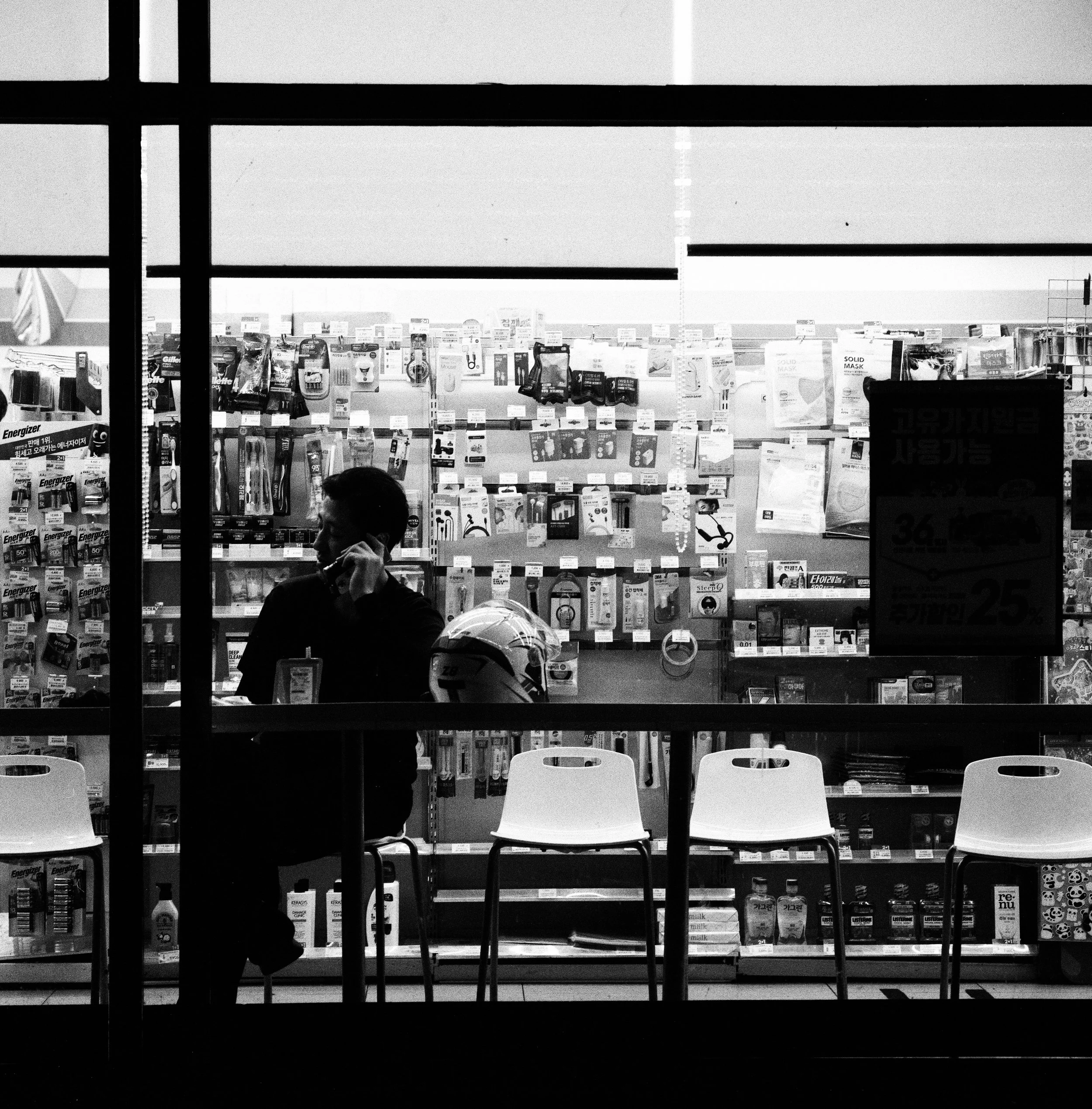 Black and White Photography of Man on the phone inside a Korean Convenience Store taken with Mamiya 6 and Mamiya 150mm f4.5