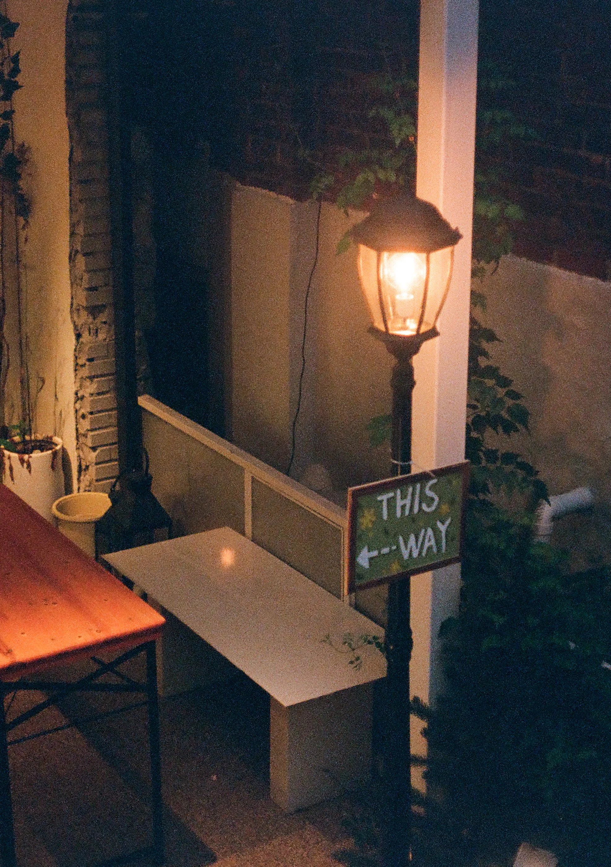 Street lamp at night with a sign that says "This Way" and an arrow pointing left. Taken on Olympus Pen FT with Kodak Ultramax 400 and processed by Yeonnam Film