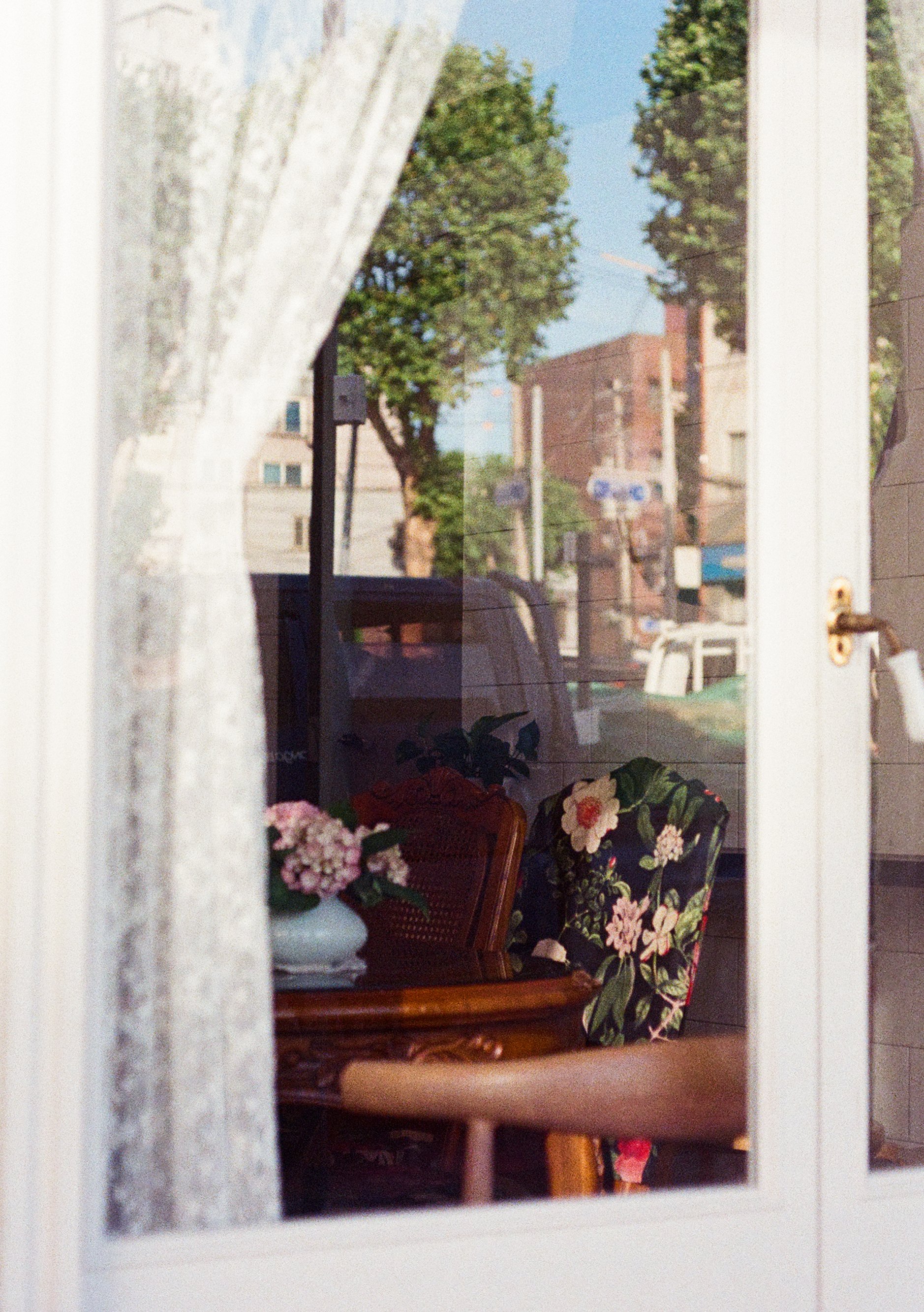 Image of chairs, a table and a vase of flowers shot through a window. Taken on Olympus Pen FT with Kodak Ultramax 400 and processed by Yeonnam Film