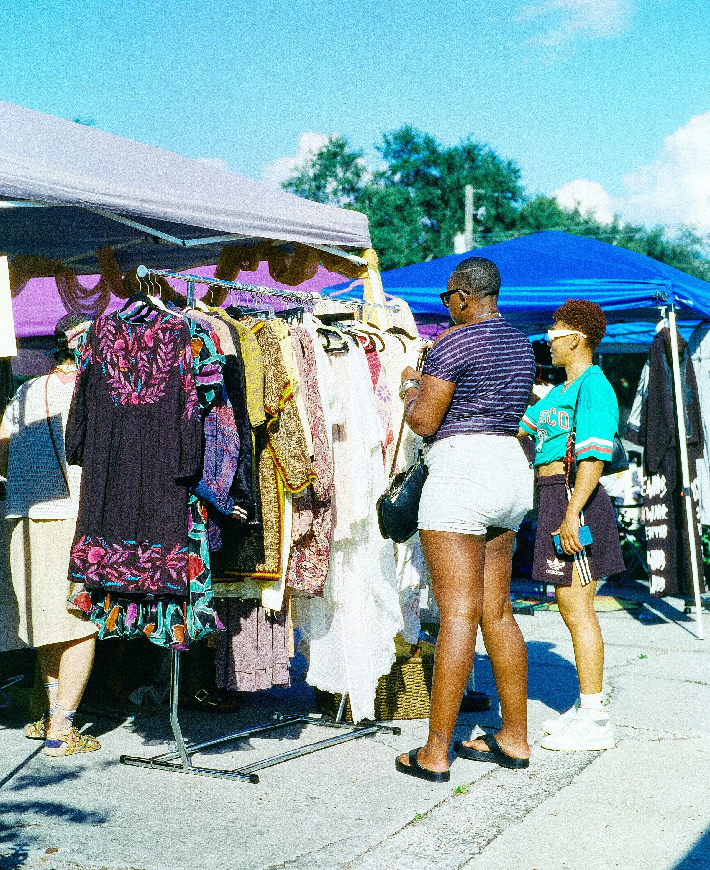 Film photograph of two women shopping at a vintage marker