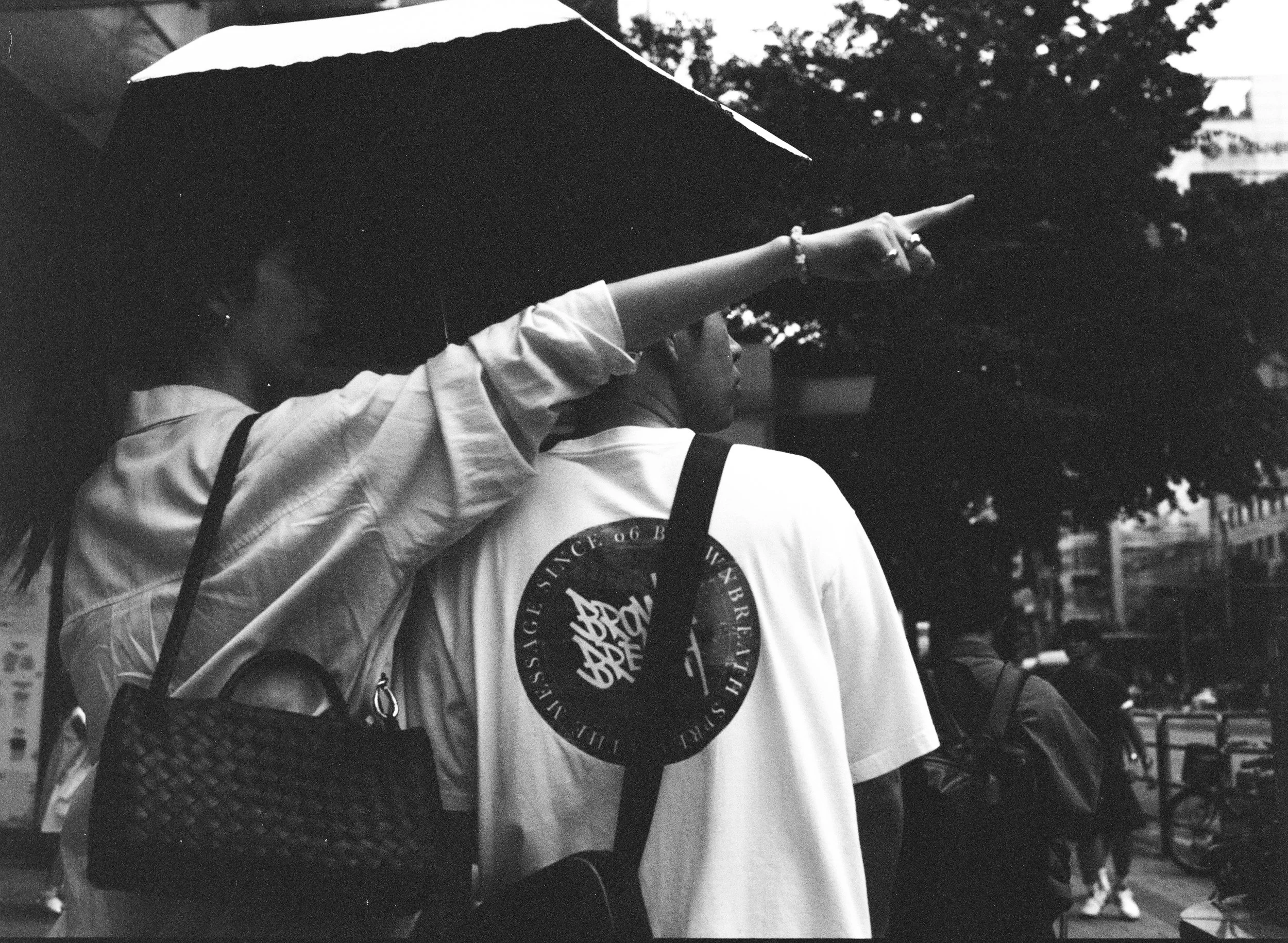 Black and white picture of woman pointing to the right and a man looking to the right.