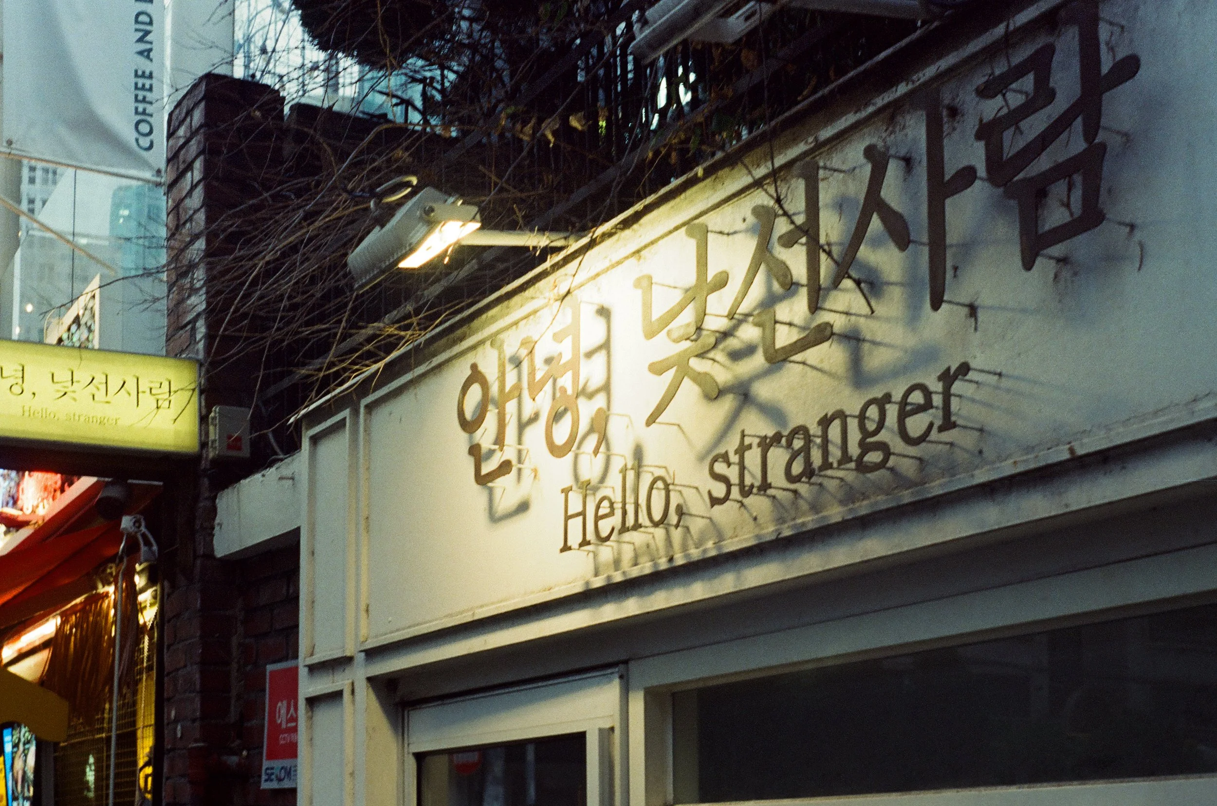 Sign of a korean business captured with a street camera. Reads "Hello, Stranger"