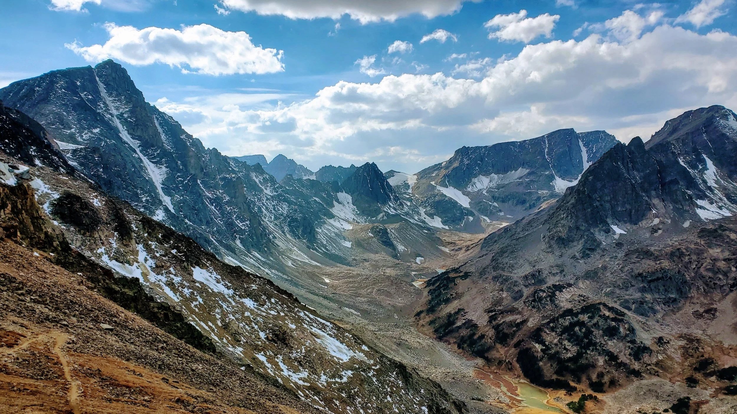Snow-capped mountain peaks under a partly cloudy sky.