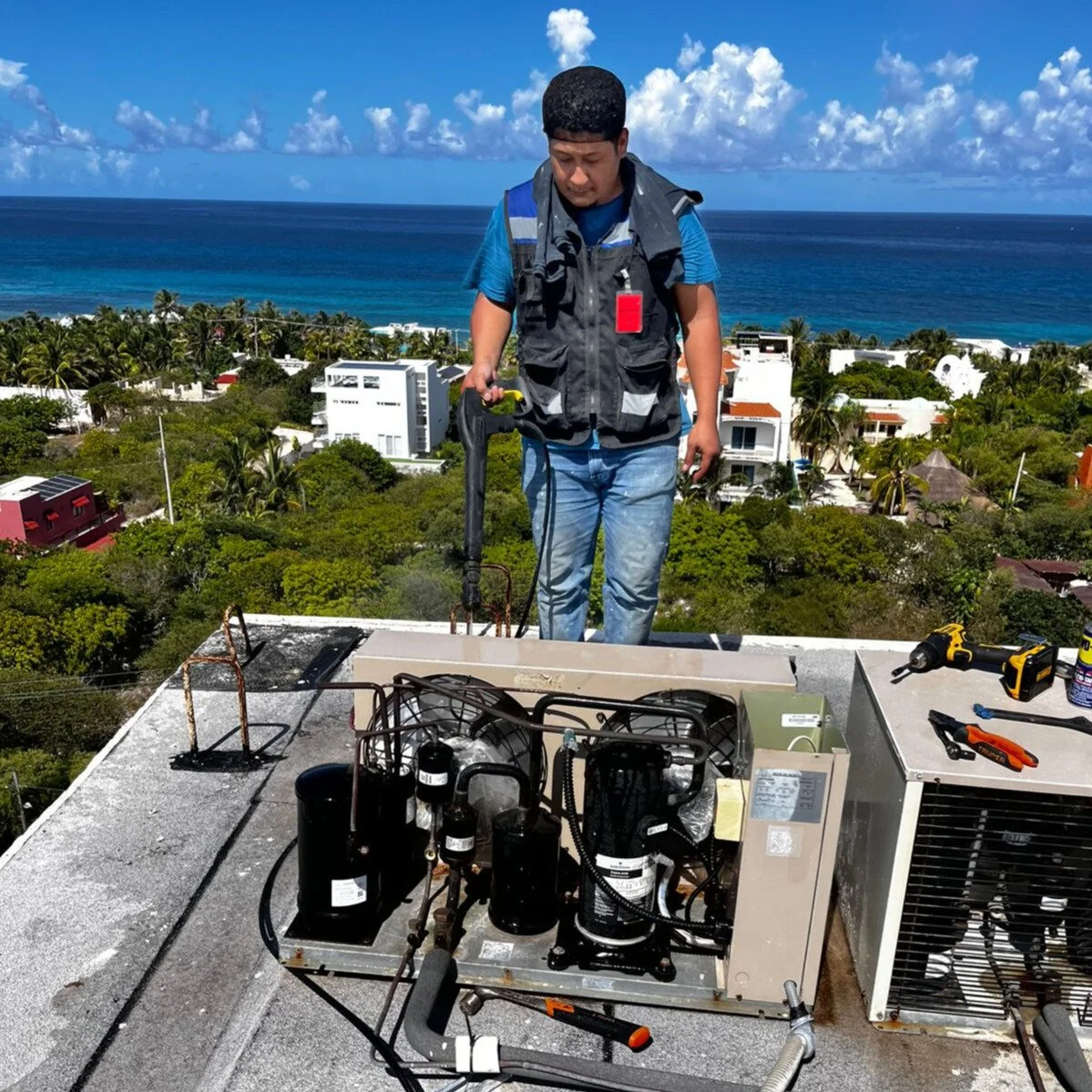 Técnico realizando servicio  a Unidad Condensadora en la azotea de un edificio.