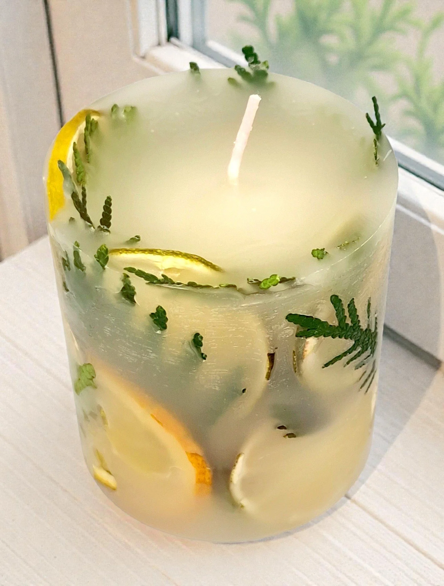 Kerze mit getrockneten Pflanzenteilen