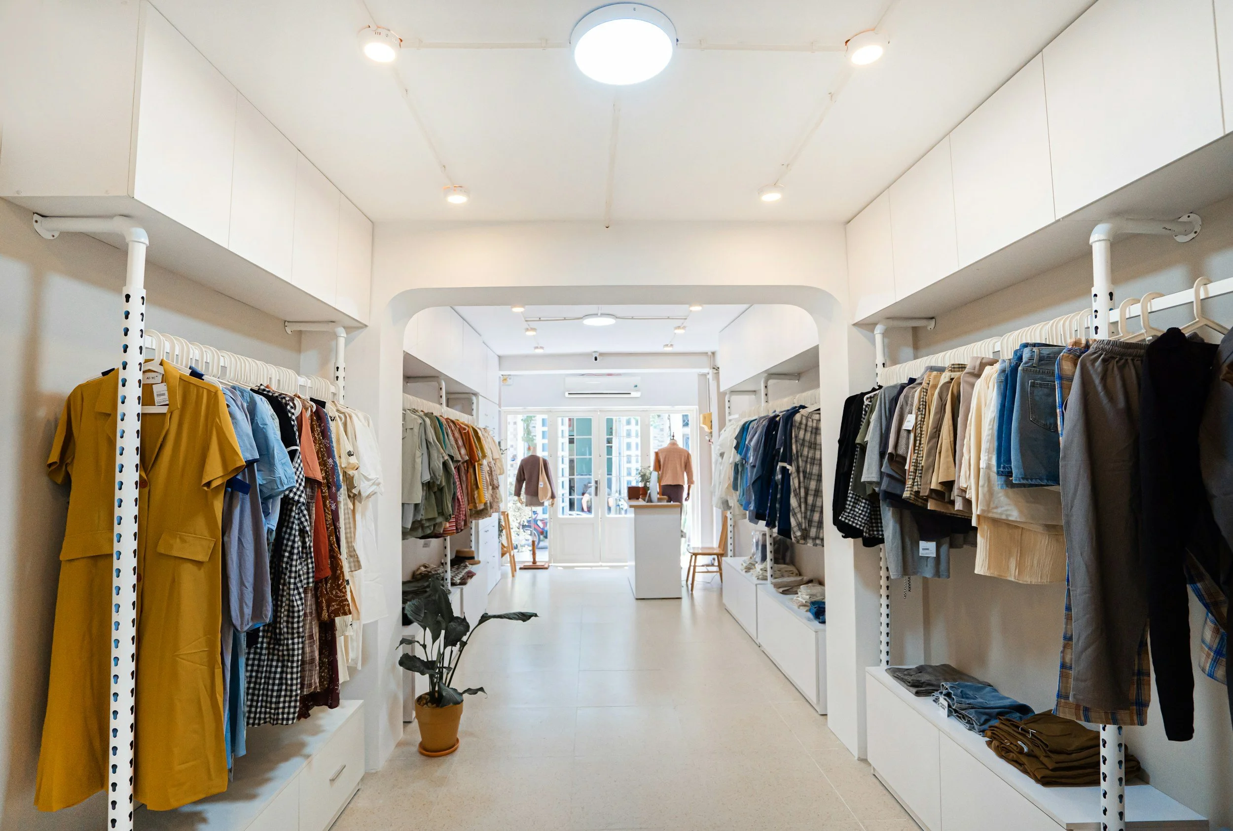 Clothing store interior with racks of casual clothes and mannequins near the entrance