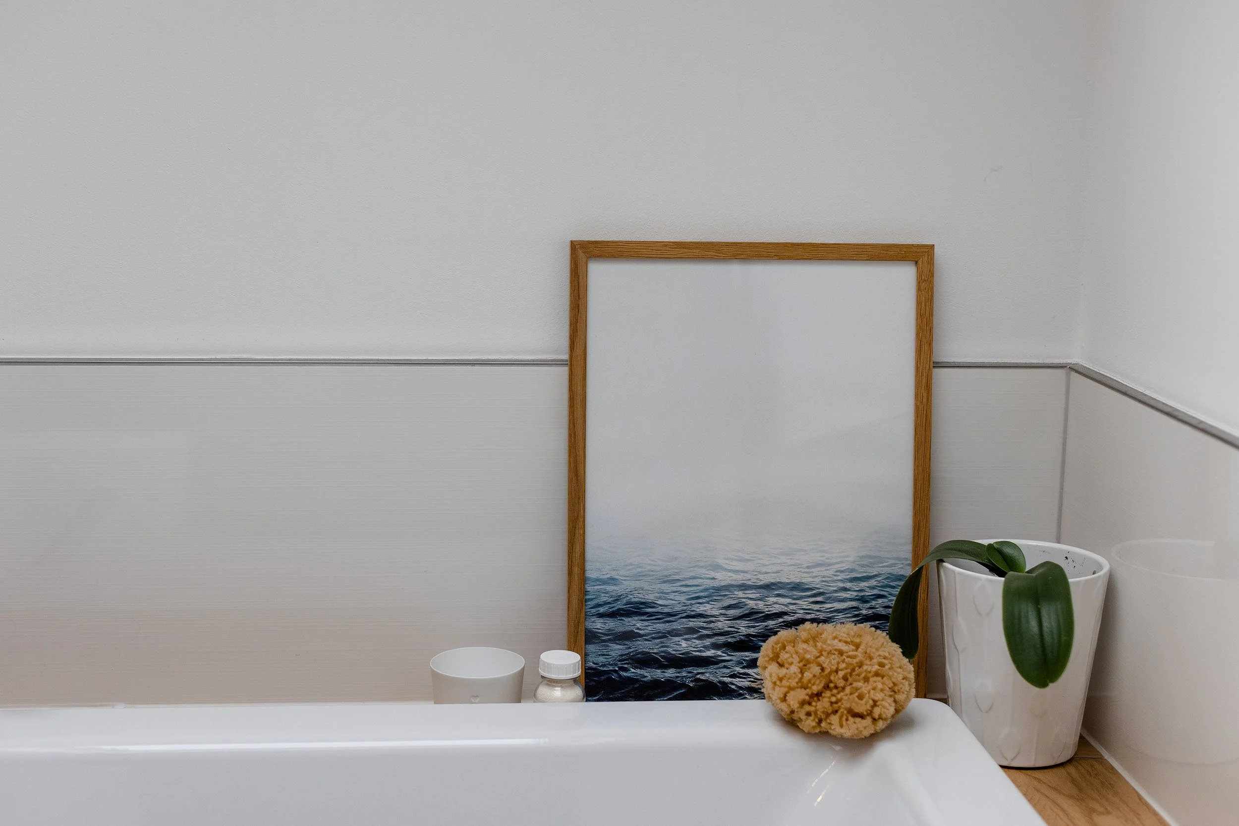 Badezimmer mit Pflanzen, Spiegel, Badekugel und Pflegeprodukte