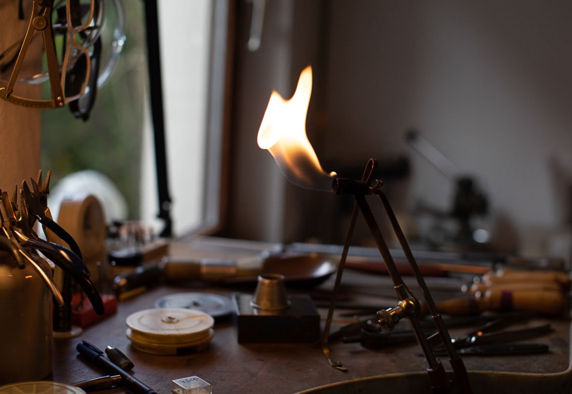 Werkbank in einem Workshop mit Flamme, Werkzeugen und Materialien.